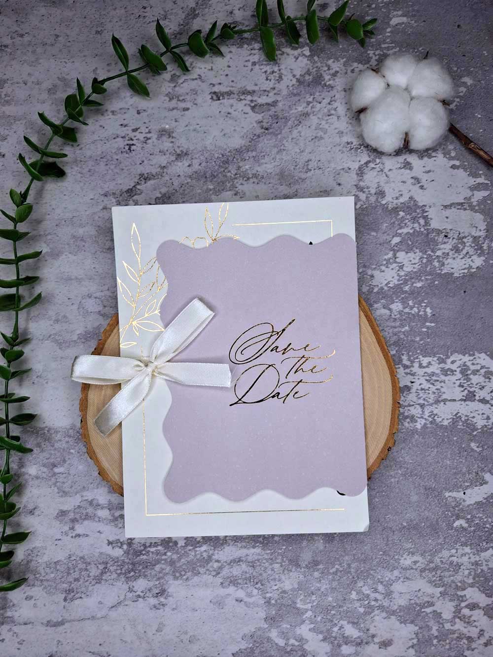 wedding-card-minimal-m365-front کارت دعوت عروسی یاس رنگ یاسی با پاکت طلاکوب Save The Date در دست عروس در فضای باغ